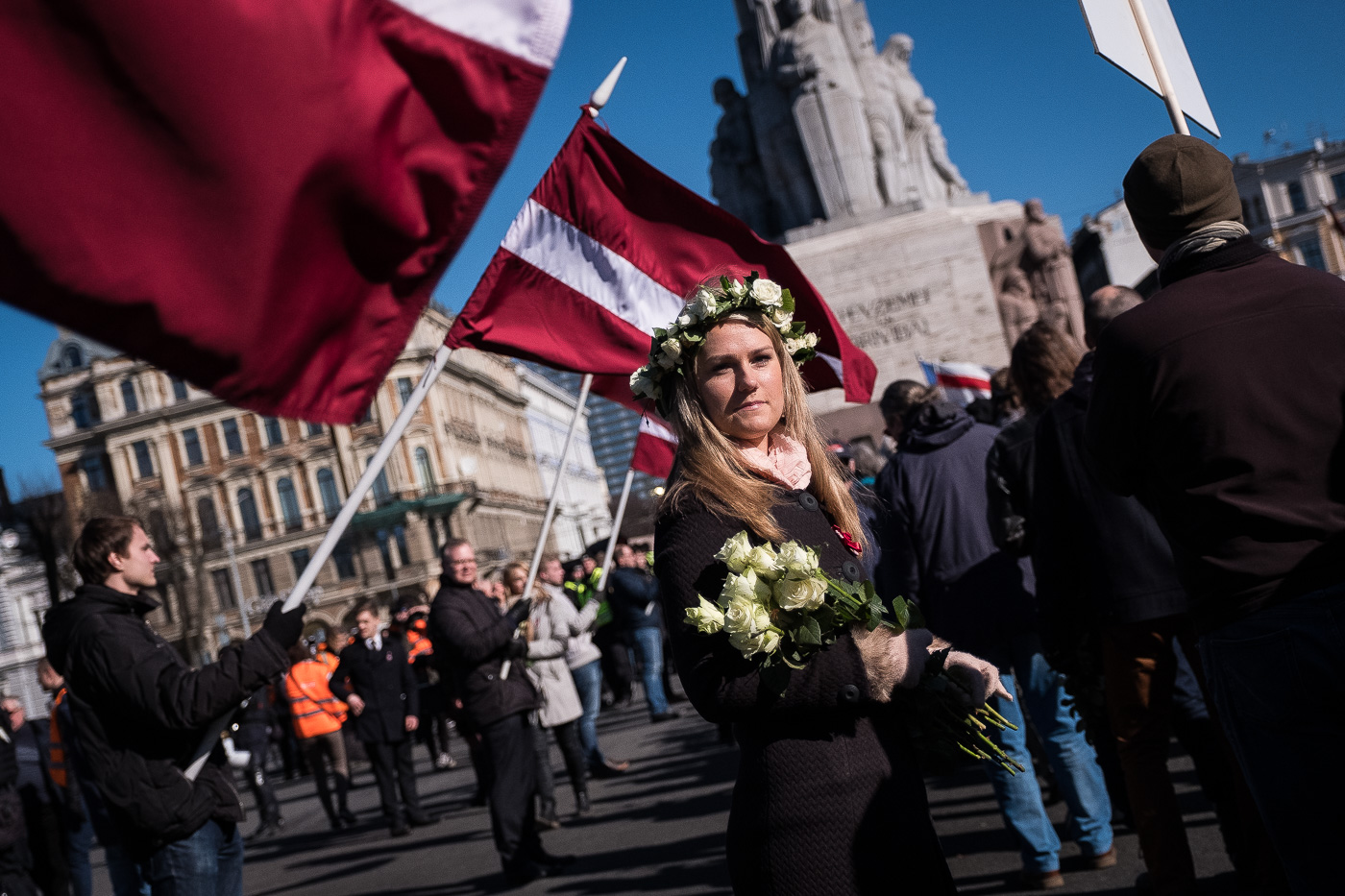 Una noia reparteix flors a la comitiva de veterans de la Legió Letona