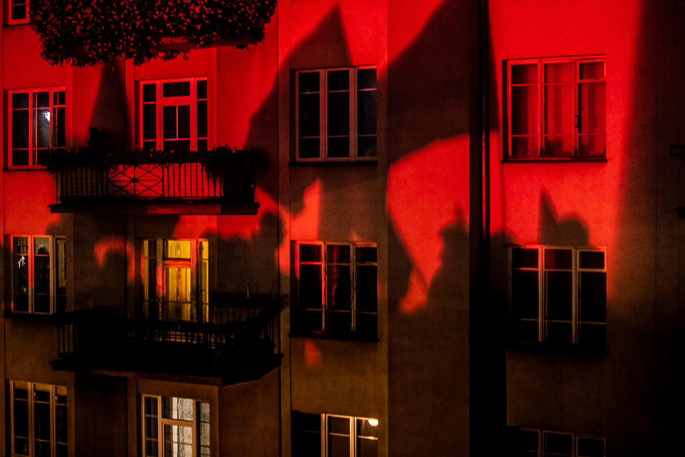 Les ombres dels manifestants i les seves banderes projectades a la façana d’un bloc d’apartaments a Varsòvia